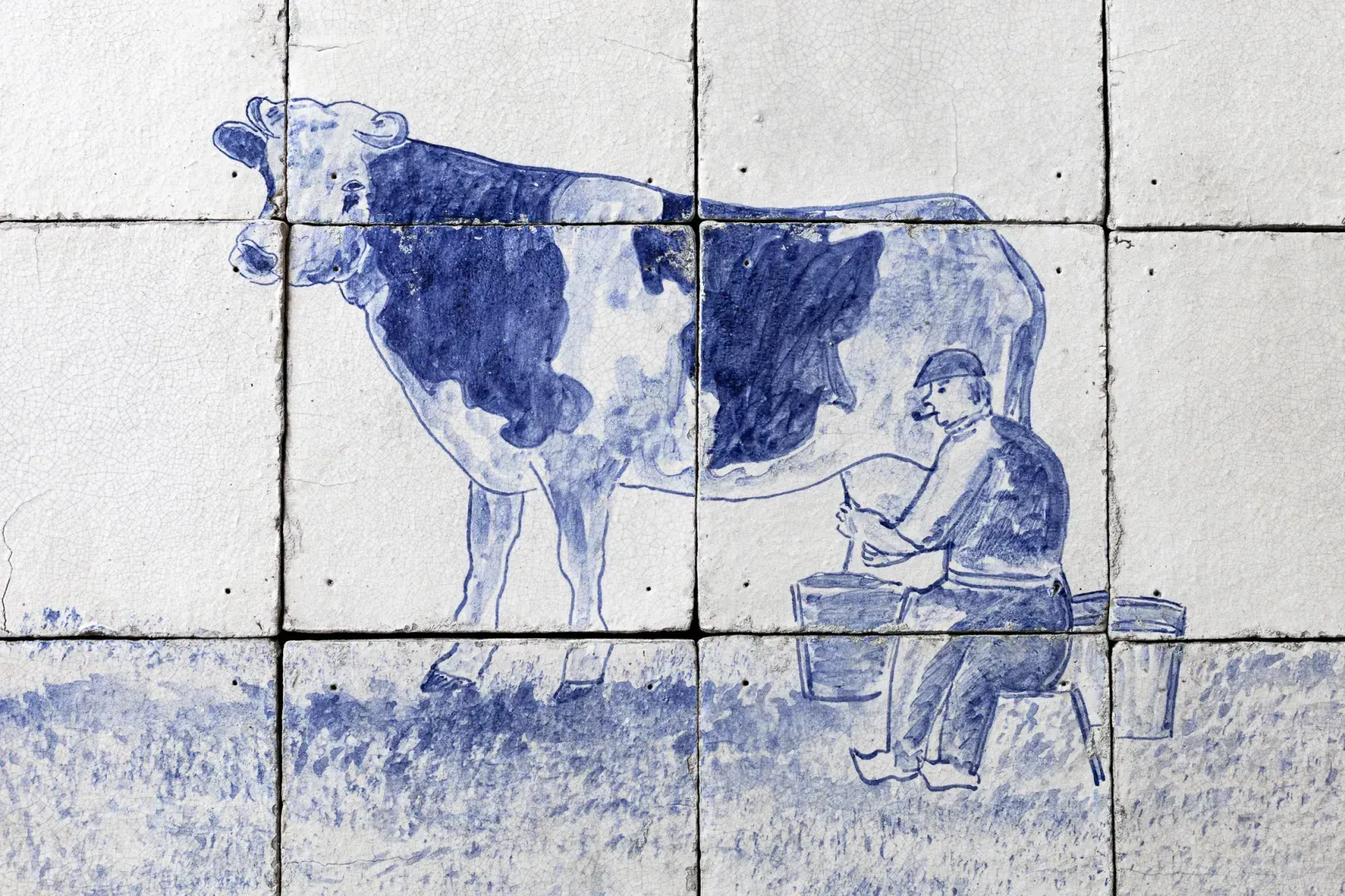 Antique Delft blue tile panel showing a farmer milking