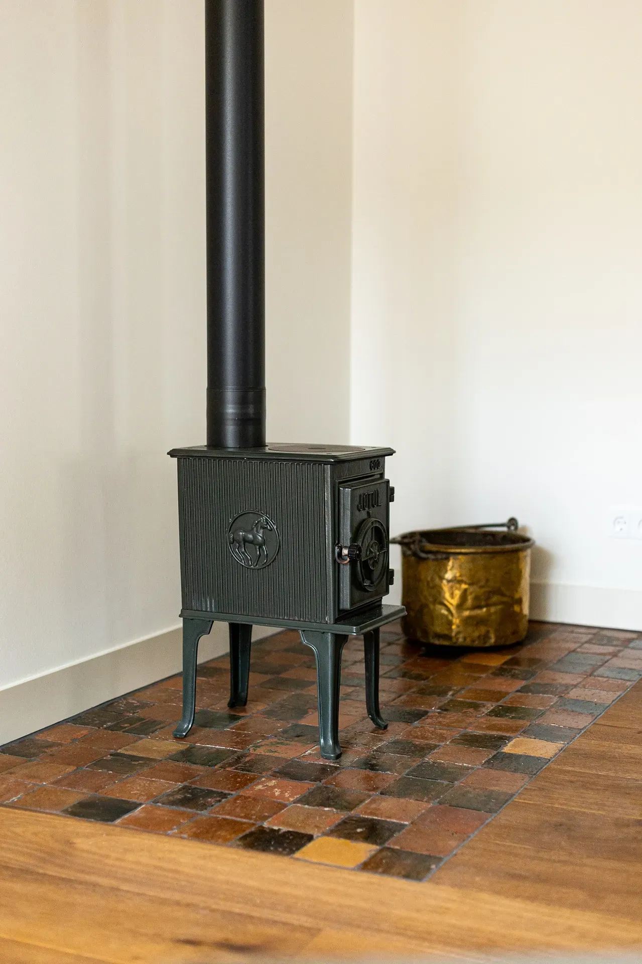 Antique terracotta floor tiles beneath a fireplace or stove
