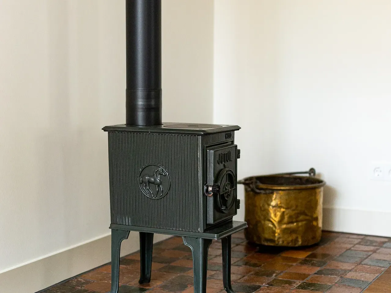 Antique terracotta floor tiles beneath a fireplace or stove