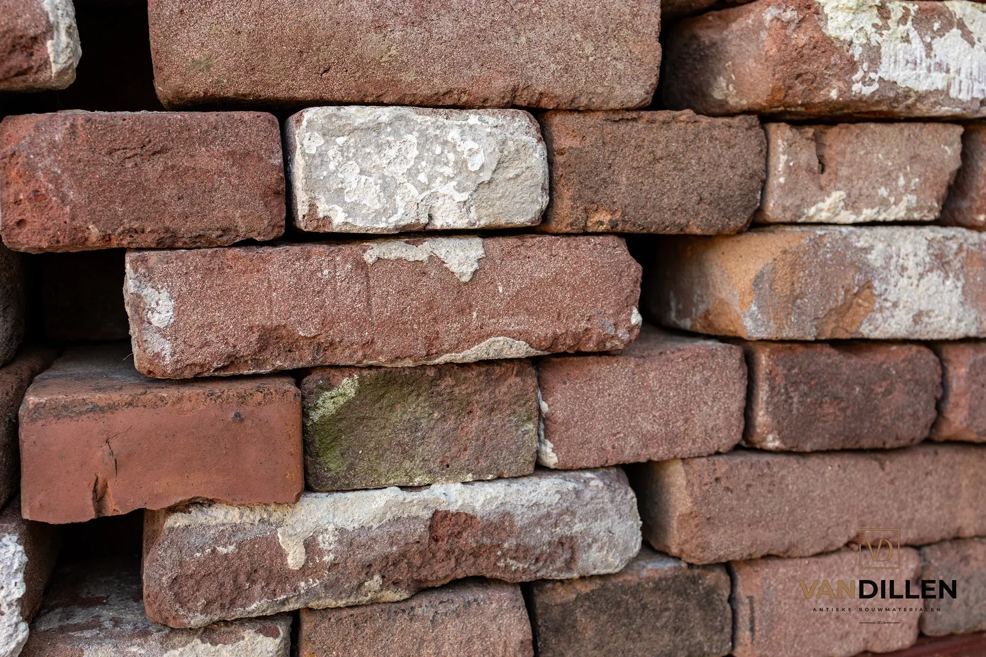 Old dark purple-brown facing bricks cleaned of mortar