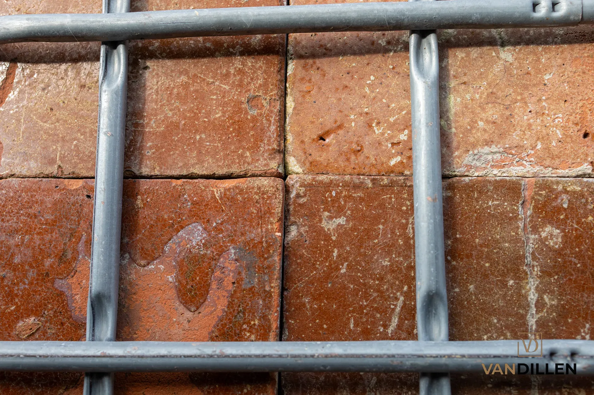 Old glazed floor tiles in brown-red