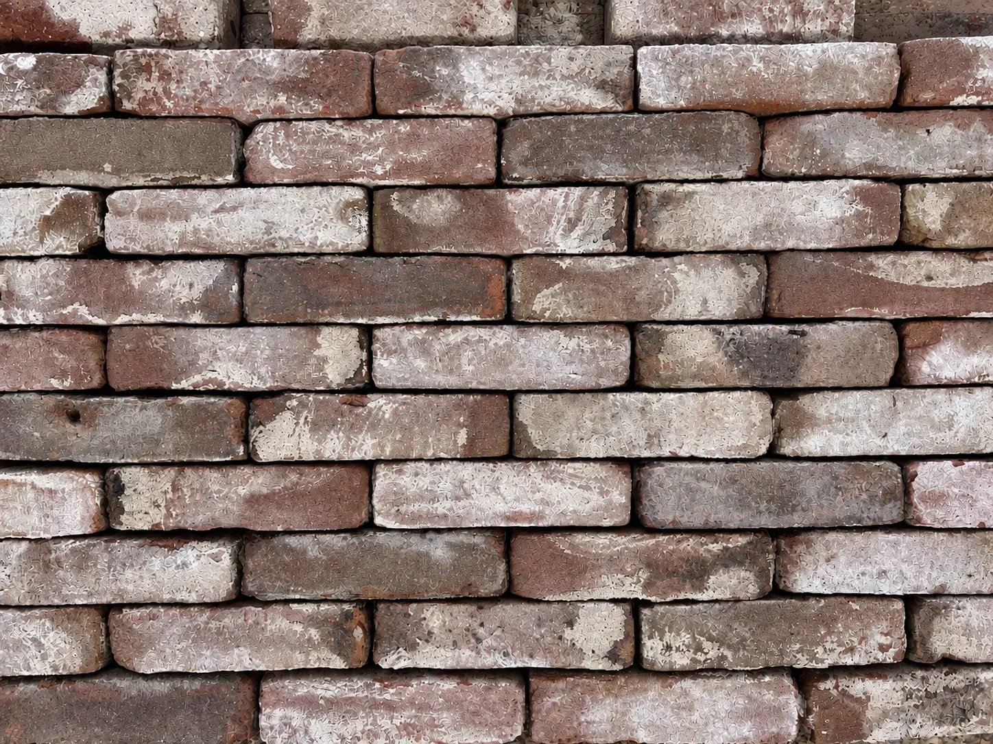 Oude gebikte rood bruine paarse vormbak stenen, old reclaimed bricks with nuance of being used